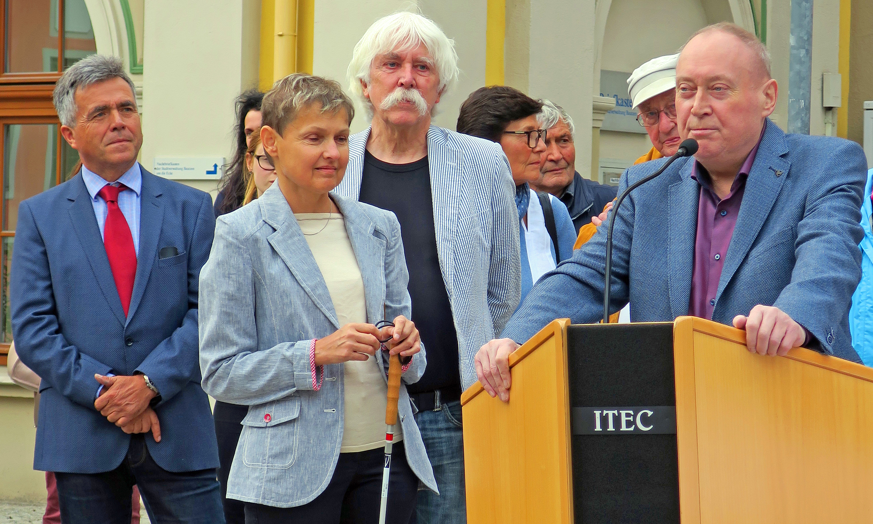 Der Landrat des sächsischen Landkreises Bautzen Hr. Harig, die Landesvorsitzende des BSVS Fr. Fischer, der Modellkünstler Hr. Broerken, (von links nach rechts) stehen neben dem Rednerpult. Am Rednerpult steht der Projektinitiator Herr Noak von der KO Bautzen.