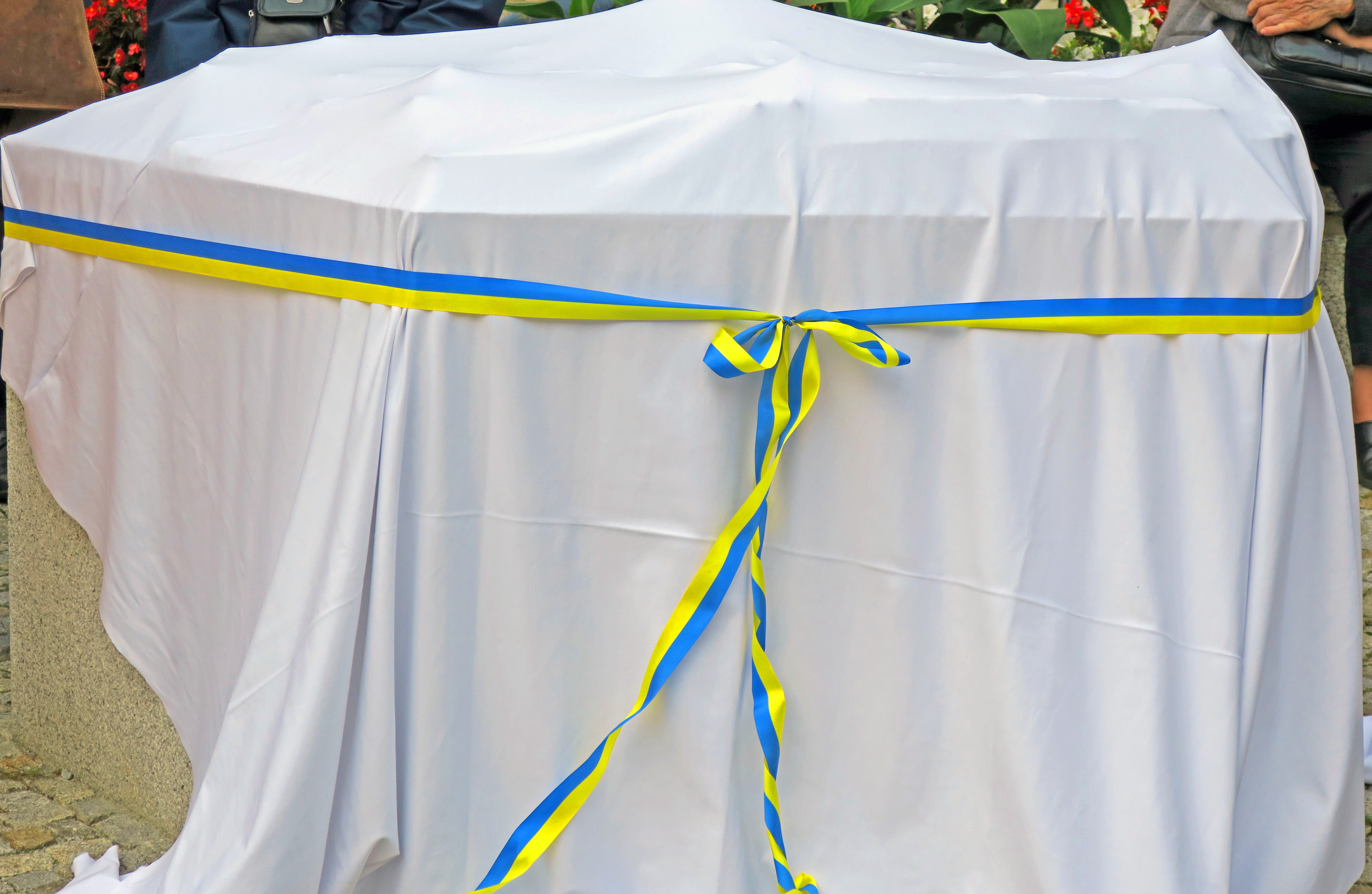Das Altstadttastmodell ist mit einem weißen Laken abgedeckt und ein blau-gelbes Schleifenband ziert die Abdeckung.