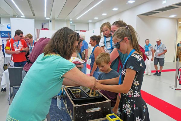 Kongresshalle - EXPO - Markt der Begegnungen - Stand Nikolauspflege - Eine Besucherin hat eine Simulationsbrille auf stellt eine Grillanzünder unter Anleitung her.