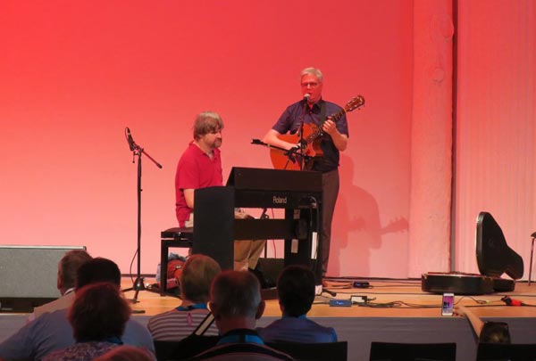 Großer Saal - Kongresshalle - Auf der Bühne stehen Herr Professor Dr. Thomas Kahlisch singt und spielt Gitarre. Vor ihm sitzt der Moderator Olaf Garbow welcher durch das Programm Open Stage führt.