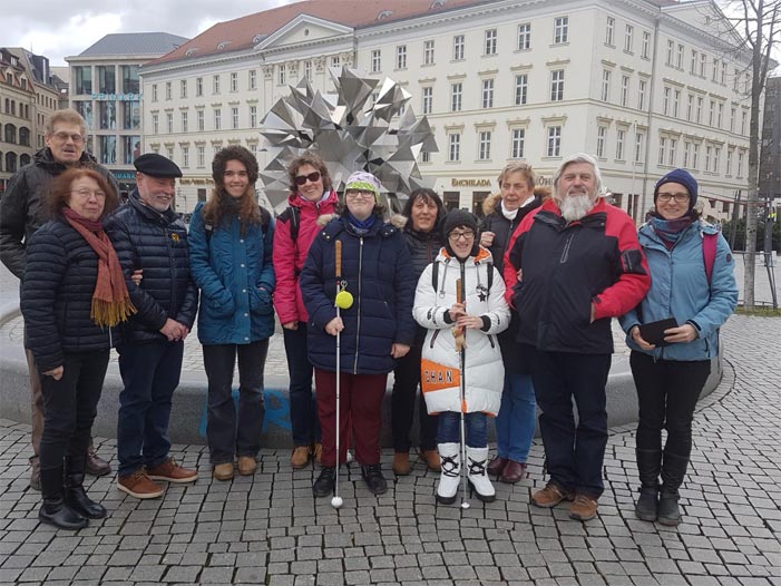 Fünf Mitglieder und deren Begleitpersonen vor einem Springbrunnen auf dem Brühl in Leipzig