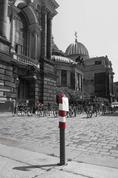 An der Frauenkirche, ein Poller im Vordergrund hat rotweiße Mütze