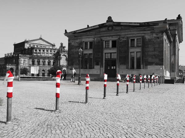 Sophienstraße mit Blick auf Altstädtische Hauptwache und Semperoper, von 16 grauen Pollern tragen 13 rotweiße Mützen