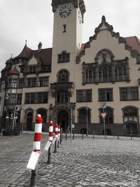 Marktplatz Waldheim mit Rathaus, graue Poller tragen rotweißgestreifte Mützen