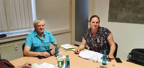 Am Konferenztisch beim Blinden- und Sehbehindertenverband Sachsen e.V. sitzt links Herr Schneider (stellvertretender Landesvorsitzende) und rechts FrauČagalj Sejdi (Bündnis 90/Die Grünen).