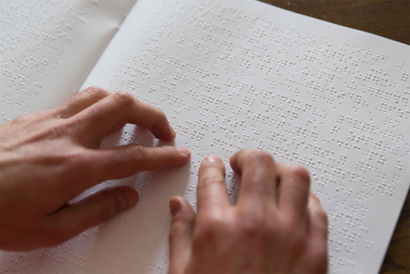 Abbildung einer Braille-lesenden Person