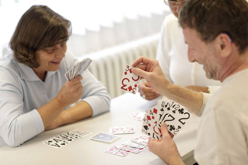 Abbildung einer geselligen Runde beim Kartenspiel