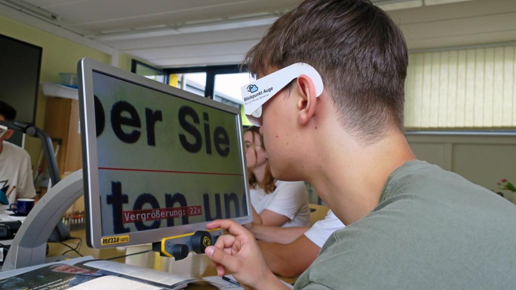 Der Schüler Tim Küster ist begeistert, denn er kann trotz Simulation einer Sehschärfe von nur noch 10 % Zeitungsdruck lesen – Dank eines Bildschirmlesegerätes, welches die Schrift entsprechend vergrößert und kontrastreich darstellt. Eine rote Führungslinie unterstützt den Lesevorgang zusätzlich.