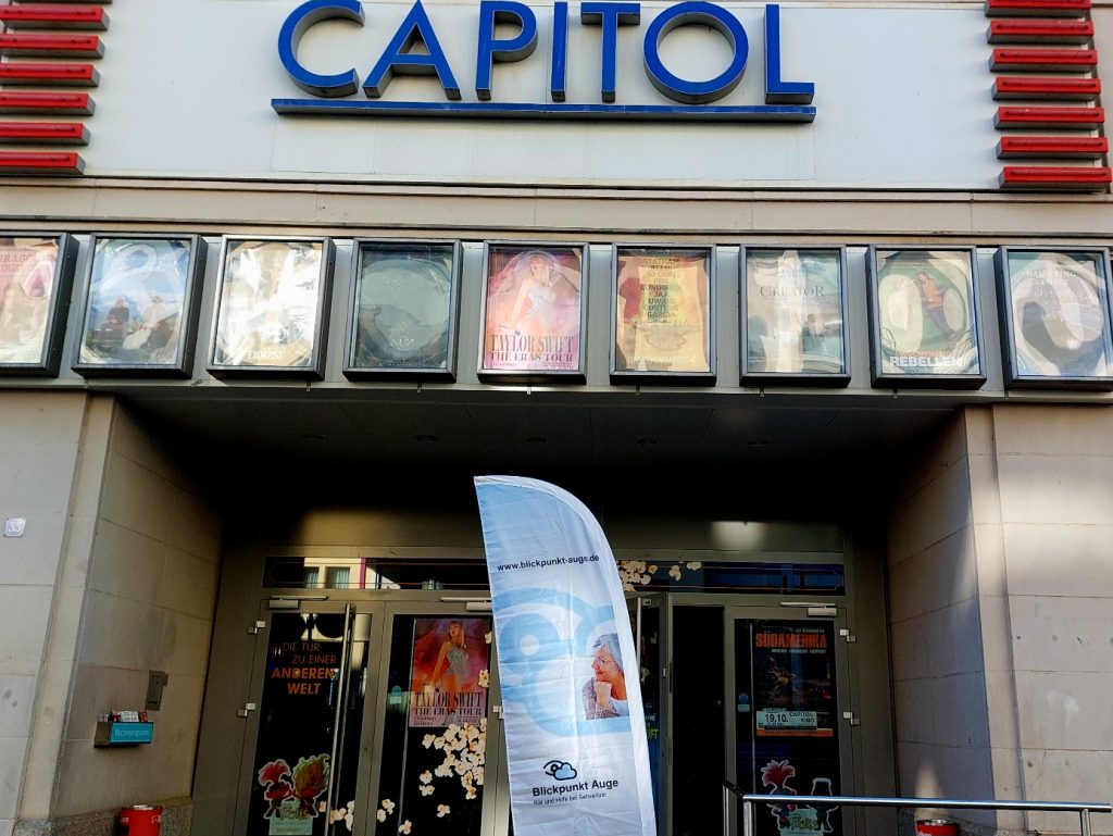 Vor dem Filmtheater Capitol in Plauen weist ein großes Banner mit dem Logo von Blickpunkt Auge auf die Veranstaltung zur Woche des Sehens hin.