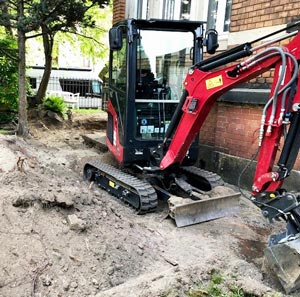 Ein Bagger hebt Erde aus, um Leitstreifen und Beratungsflächen einzurichten.