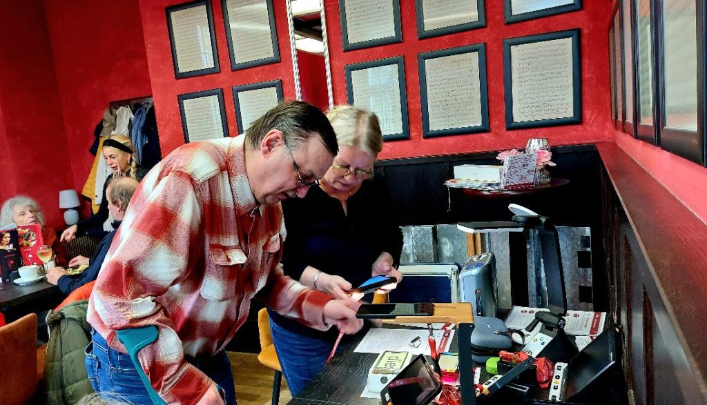 Angelica Schüttauf von der Firma BeTa Hilfen für Sehgeschädigte berät einen Teilnehmer an ihrem Stand mit Hilfsmitteln